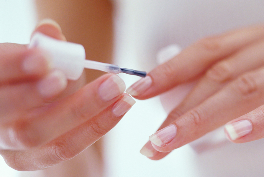 Young woman painting fingernails, close-up